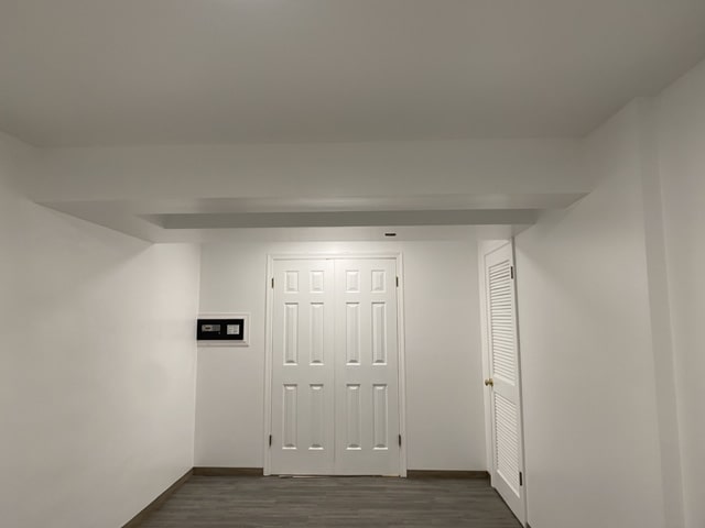 Finished basement room with white walls and gray vinyl plank flooring