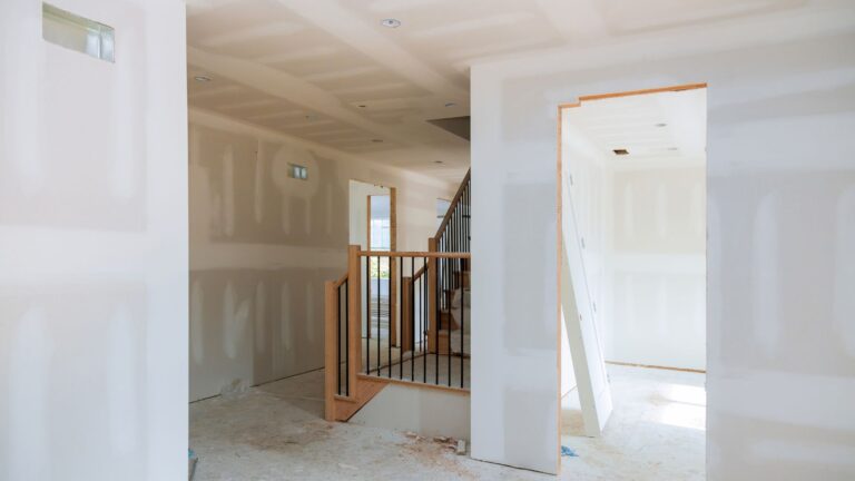 Home interior during a remodel with new drywall and a staircase